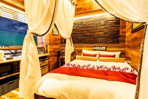 1 dormitorio con cama con dosel y almohadas rojas y blancas en Petit Bali Forest Shinjuku Sanchōme en Tokio