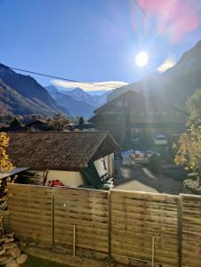 a fence in front of a house with mountains in the background at Hubel Apartment 14 in Wilderswil