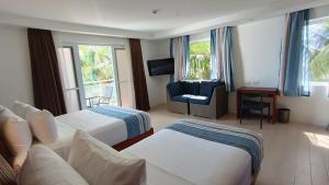 a hotel room with two beds and a couch and a chair at Aira Boracay Hotel in Boracay