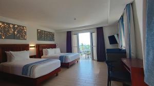 Aira Boracay Hotel في بوراكاي: غرفة فندقية بسريرين وبلكونة