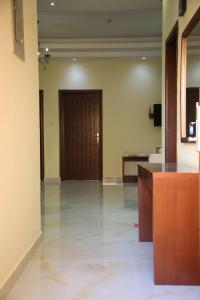an empty lobby with a wooden door and a hallway at Park Complex in Salalah