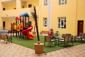 a playground with a table and chairs and a slide at Park Complex in Salalah