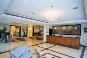 a living room with a large tv and a chandelier at Royal Prestige Hotel in Dubai