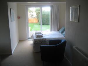 ニューキーにあるPriory Lodge Hotelのベッドと椅子と窓のある寝室