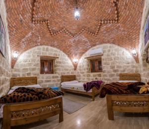 Habitación con 2 camas y pared de ladrillo en Zad El Mosafer Guest House, en Tunis