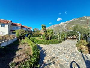 einen Kopfsteinpflasterweg, der zu einem Haus mit einem Berg führt in der Unterkunft Villa Sophia in Loutraki