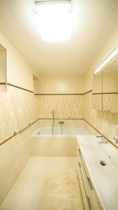 Baño blanco con bañera y lavamanos en Elite House, en Moravany nad Váhom