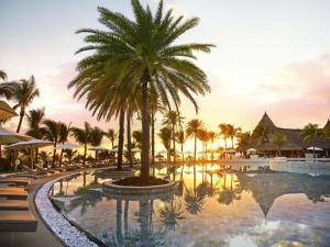 ośrodek z palmą i basenem w obiekcie LUX* Belle Mare Resort & Villas w mieście Belle Mare