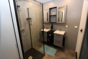 a bathroom with two sinks and a glass shower at Strandhuisje achter de duinen. in Julianadorp +22 photos