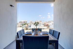 a dining table with chairs and a view of a city at Perfect Location Idyllic 2BR Apartment in Sliema