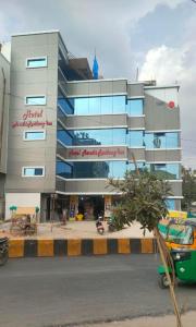 um edifício com uma árvore em frente em Hotel New Maruthi Inn, LB Nagar em Hyderabad