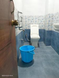 uma casa de banho com WC e um balde azul em Hotel New Maruthi Inn, LB Nagar em Hyderabad