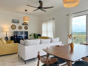 a living room with a white couch and a table at BayView Suites Port Dickson By MAISON in Port Dickson
