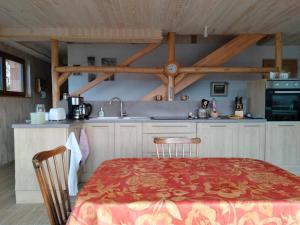 cocina con mesa, sillas y fregadero en Chez Nous, en La Bresse