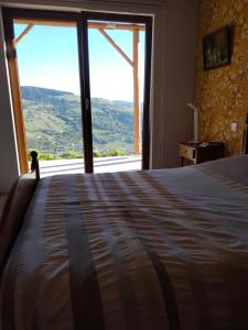 a bedroom with a large bed and a large window at Chez Nous in La Bresse