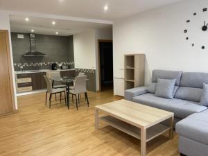 uma sala de estar com um sofá e uma mesa em Apartamentos Turísticos LOS BARRUECOS em Cáceres