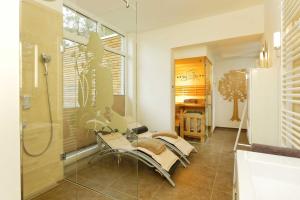 a bathroom with a glass shower and a chair at Straße der Freundschaft 30c in Ostseebad Karlshagen