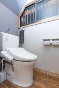 ein weißes WC im Bad mit Fenster in der Unterkunft Mita Guest House by Tranova in Tokio