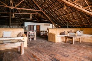 uma sala de estar com dois sofás e uma mesa em Raha Lodge Zanzibar Boutique Hotel em Jambiani