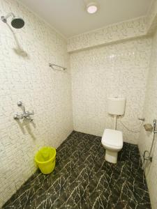 bagno con servizi igienici e secchio giallo di HOTEL THE AVENUE a Gamhāria