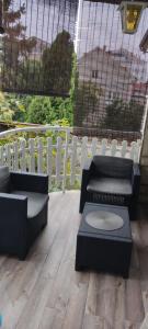 eine Terrasse mit 2 Sofas, einem Tisch und einem Zaun in der Unterkunft Cerak lux in Bele Vode