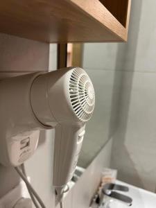 Hay un secador de pelo blanco junto a un lavabo. en Penzión Elements en Trnava