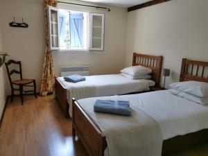 1 dormitorio con 2 camas y ventana en L'Ancienne Distillerie en Segonzac