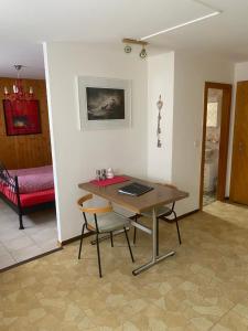 a room with a table and chairs and a bed at Ferienwohnung Allalinblick in Saas-Fee