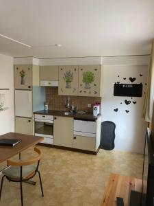 a kitchen with white cabinets and a table and a table at Ferienwohnung Allalinblick in Saas-Fee
