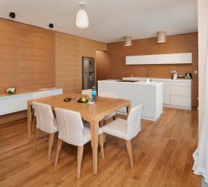 D-Resort Šibenik في شيبينيك: مطبخ وغرفة طعام مع طاولة وكراسي خشبية