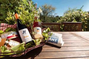 una cesta de comida y vino en una mesa en Belle villa moderne 3 chambres, jardins terrasse piscine, en Durban-Corbières