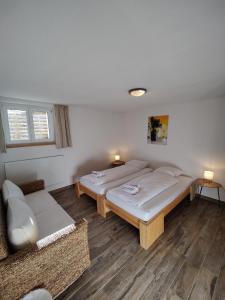 una camera con due letti e un divano di Hubel Apartment 14 a Wilderswil