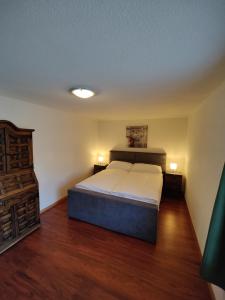 um quarto com uma cama grande num quarto com pisos de madeira em Hubel Apartment 14 em Wilderswil