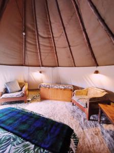 a room with two beds and a table in a tent at Forest Harmony in Knysna