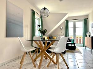 une salle à manger avec une table et des chaises blanches dans l'établissement Reethaus Boddenblick - Apt. 16, à Alt Reddevitz
