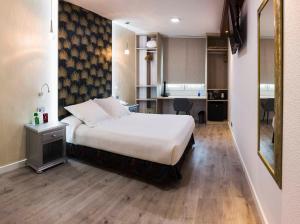 ein Hotelzimmer mit einem Bett und einer Küche in der Unterkunft Bellavista Sevilla in Sevilla