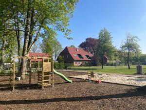 a playground with a slide in a park at Meine Schule Sehlingen, Familien-Apartment mit Sauna & Spielplatz! in Kirchlinteln