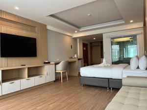 a bedroom with a bed and a flat screen tv at เดอะสแควร์โฮเทลนครพนม in Nakhon Phanom