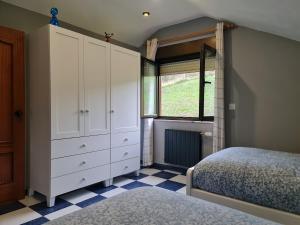 a bedroom with a bed and a dresser and a window at La Centinela, Geoparque Costa Quebrada in Miengo