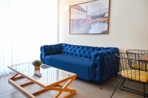 a blue couch in a living room with a table at Life`s A Beach by HolyGuest in Tel Aviv
