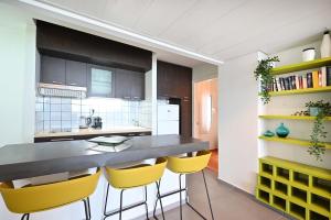 a kitchen with a counter and yellow chairs in it at Life`s A Beach by HolyGuest in Tel Aviv