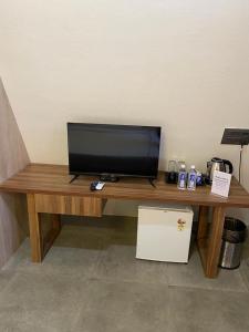 a wooden table with a television on top of it at NAMASTE BEACH RESORT in Jāmb