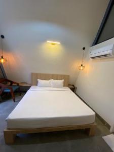 a bedroom with a large white bed in a room at NAMASTE BEACH RESORT in Jāmb