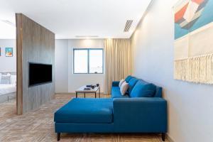 The Seasons Hotel في المدينة المنورة: غرفة معيشة مع أريكة زرقاء وتلفزيون