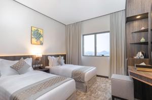 um quarto de hotel com duas camas e uma janela em The Seasons Hotel em Al Madinah