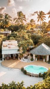 uma vista para um resort com uma piscina e palmeiras em Zanzibar White Sand Luxury Villas & Spa - Relais & Chateaux em Paje