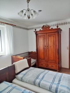 a bedroom with a bed and a wooden cabinet at Ferienwohnung Pasek in Mehlmeisel