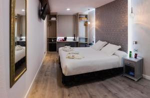 a hotel room with a large white bed and a mirror at Bellavista Sevilla in Seville