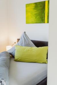 a yellow pillow sitting on top of a bed at Wohnen auf Zeit in Weingarten in Weingarten