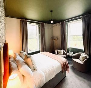 a bedroom with a large bed and a chair at Pilgrim Hotel in Hereford
